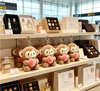 Porte-clés en peluche singe marron assis avec pêche, jouet animal en peluche, poupée singe avec breloque fruit rose
