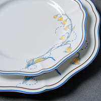 Assiette élégante à bord festonné en porcelaine fine, bol à soupe avec décor floral, bord bleu et doré, assiette creuse pour hôtels, mariages, vente en gros