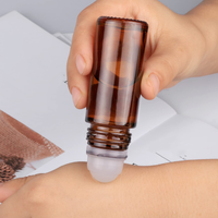Flacon roll-on vide en verre ambré de 30 ml et 50 ml avec bille en quartz rose, emballé dans un carton sérigraphié
