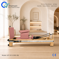 Reformer de Pilates en bois de chêne rose poussiéreux avec barre de pieds intégrée et barre spécialisée pour cours de bien-être en boutique