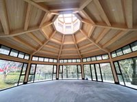 Maison en bois contemporaine avec un design géométrique et des murs en verre, idéale pour un hôtel boutique avec vue sur la mer ou la forêt