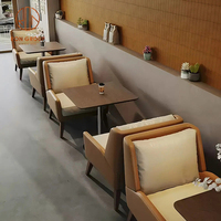 Ensemble de meubles de café, de restaurant et de salon moderne, canapés en cuir beige et marron, sièges en banquette, tables en bois brun