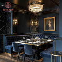 Ensemble de chaises de banquettes en velours bleu foncé européen avec table en marbre à bordure dorée et structure métallique pour salle à manger, café, restaurant, hôtel
