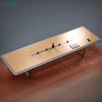Table de conférence moderne à LED avec prise électrique et surface en placage de bois pour salle de réunion de direction