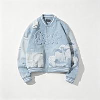 Blouson de baseball en jean vieilli avec broderie chenille, lettres, accent nuage et strass, poignets côtelés, coupe oversize