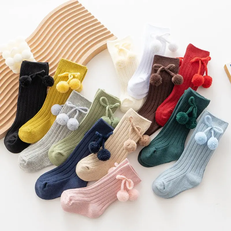 Fuyu Vente en gros Chaussettes de princesse à tube moyen pour bébés garçons et filles avec pompon Chaussettes de mode solides pour bébés