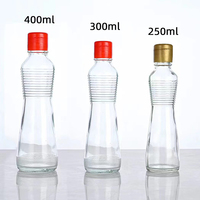 Bouteille cylindrique en verre transparent en gros avec bec verseur en plastique pour l'emballage d'huile d'olive, de vinaigre, de sauces et d'assaisonnements