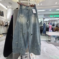 Nouvelles collections automne 2026 : Jean scimitar en denim bleu délavé pour femme, taille haute, coupe ample, jambe large, déchiré, style décontracté chic pour le quotidien.