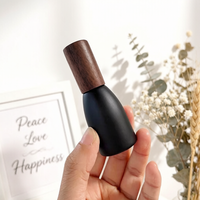 Vente en gros de flacons à bille en verre noir mat opaque de 12 ml, flacons de luxe pour huiles parfumées avec bille en acier et couvercle en bois foncé naturel