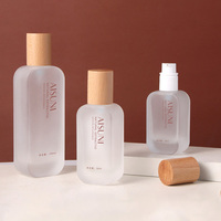 Les nouveaux flacons cosmétiques en bois sont emballés séparément en pressant le flacon en verre de lotion essence avec pompe et le pot de crème pour le visage.
