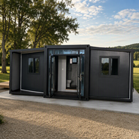 Maison conteneur pliable extensible noir mat avec porte ouvrante pour le glamping et l'hébergement temporaire