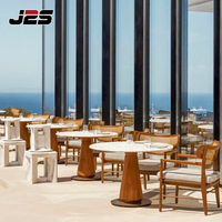 Ensemble de meubles de restaurant en teck d'extérieur moderne et durable J2S avec table ronde en bois et chaises pour utilisation commerciale sur la terrasse d'un hôtel