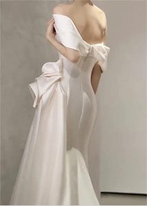 Un vestido de un solo hombro de satén blanco con pajaritas y cola, adecuado para bodas y fiestas nocturnas. - Product Image 3