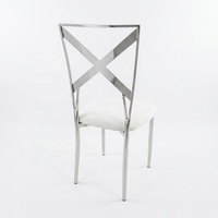 Chaise de mariage moderne en acier inoxydable argenté avec dossier croisé et coussin en velours blanc, idéale pour la location d'événements et banquets, vente en gros