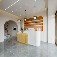 Comptoir de réception de salon de beauté incurvé en MDF blanc avec logo gravé personnalisé rétroéclairé par LED