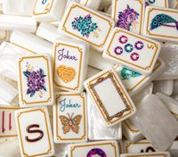 Tuiles de Mahjong américaines blanches nacrées avec des bords dorés et des motifs inspirés des bijoux pour des soirées de jeu élégantes