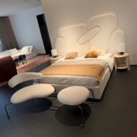 Fauteuil lounge moderne en bouclette avec ottoman intégré, style chaise longue crème, dossier incurvé et structure en métal bronze