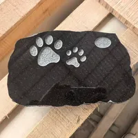 Pierre tombale moderne en granit américain pour animaux de compagnie avec motif d'empreintes noires, finition polie et sablée pour usage funéraire