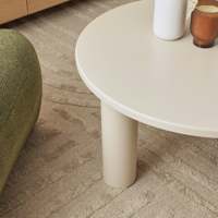 Table basse ronde moderne en crème avec pieds cylindriques pour salon