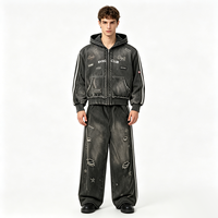 Ensemble de survêtement streetwear délavé avec sweat à capuche zippé et pantalon large, orné de patchs lettres gothiques Kornit DTG et rivets déchirés