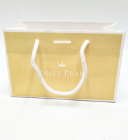 Bolsa de regalo de papel laminado al por mayor con asa de cinta y logotipo impreso personalizado para embalaje de joyería, ropa y calzado.