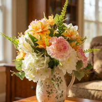 Künstlicher Strauß mit rosa Nelken und orangefarbenen Lilien, gemischtes weißes Hortensien-Kunstblumen-Set mit grüner Rankenoptik und cremefarbener Krugvase