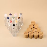 Vente en gros de flacons cylindriques en verre transparent de 5 ml et 10 ml avec bouchon en bambou naturel et bille en pierre précieuse pour huiles essentielles et parfums