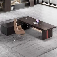 Bureau de direction en forme de L avec plateau en bois foncé, panneau gris et accents orange-rouge, bureau d'angle pour manager ou patron avec tiroirs