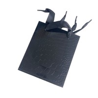 Sac en papier noir personnalisable avec motifs lézards et crocodiles, film brillant, sac cadeau haut de gamme et tendance pour magasin de vêtements