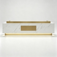 Bureau de réception de luxe en marbre blanc avec base flottante dorée et incrustation dorée centrale pour boutique et spa haut de gamme