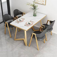 Ensemble de table de cuisine contemporaine avec table en ardoise et chaises à structure dorée