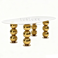 Table de banquet ovale de luxe pour hôtel, avec plateau en marbre blanc et pieds en acier inoxydable doré, idéale pour les mariages et événements.