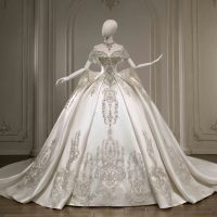 Robe de mariée moderne en satin ivoire, coupe princesse, épaules dénudées, manches courtes, ornée de perles, dentelle, broderies de cristaux et appliqués, taille naturelle