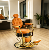 Fauteuil de barbier vintage en cuir capitonné orange avec cadre doré, fauteuil de salon hydraulique pour usage professionnel en salon de coiffure