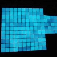 Mosaïque de verre bleu brillant brillant dans l'obscurité de la piscine