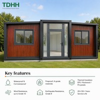Maison conteneur TDHH avec revêtement en bois grainé, porte d'entrée vitrée et structure en acier noir