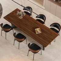 Tables à manger de style Japandi avec plateau en bois de noyer massif et base en métal brossé incurvée minimaliste pour la salle à manger moderne