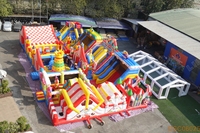 Parc d'attractions gonflable sur le thème du carnaval avec toboggans et jeux interactifs, aire de jeux commerciale pour événements en plein air