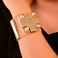 Bracelet jonc audacieux pour femme, imitation perles et cloutages dorés, style punk, bijou statement avec design manchette et bracelet de montre
