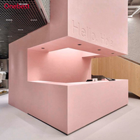Comptoir de caisse moderne en surface solide rose pour magasin de vêtements pour femmes et dames, kiosque d'accueil, présentoir