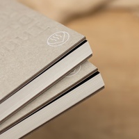 Carnet écologique en carton gris recyclé avec logo personnalisé en relief, couverture rigide, reliure cousue et fenêtre découpée