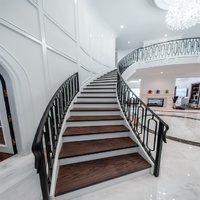 Zeitgenössische Innen-Wendeltreppe Maßgefertigte Marmorstufen Schwarzes Metallgeländer LED-Beleuchtung Geschwungene Treppe für Doppelhaus-Villa
