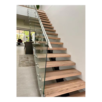 Escalier intérieur en bois foncé à une seule montante, avec poutre en acier