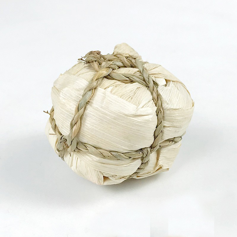 Woven ball of corn husk with water straw