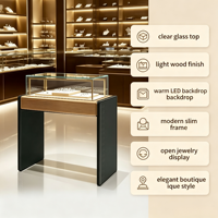 Vitrine à bijoux moderne et élégante avec dessus en bois clair, panneau latéral foncé, armoire en verre transparent avec éclairage LED chaud intégré pour la vente au détail de bijoux