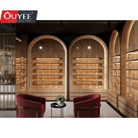 Comptoir présentoir de parfums en marbre au design d'intérieur Parfumerie unique Vitrine murale arquée en placage de bois pour parfumerie avec lumière LED
