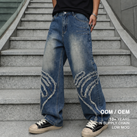 Jean ample vintage bleu pour homme avec bords bruts, appliqués, patchwork et détails effilochés, style streetwear, logo personnalisé