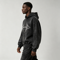 Veste à capuche zippée noire délavée effet vieilli avec détails géométriques étoiles en strass, épaules tombantes, coupe ample, style streetwear décontracté