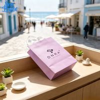 Sac fourre-tout en papier lilas imprimé avec logo personnalisé et poignées en tissu pour l'emballage de marchandises de boutique de vêtements