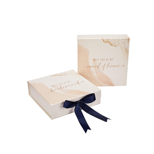 Boîte cadeau rigide rectangulaire en carton ivoire avec motif doré et ruban bleu marine pour demande en mariage à une demoiselle d'honneur - Product Image 1